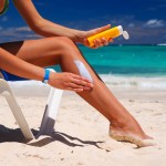 woman applying sunscreen at beach